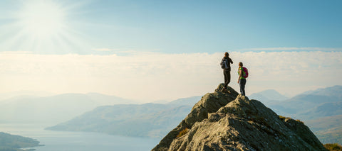 A mountain range with people hiking representing how Hall & Associates helps businesses succeed and get to the top.