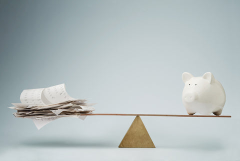 Personal tax income preparation files on a seesaw with a piggy bank.